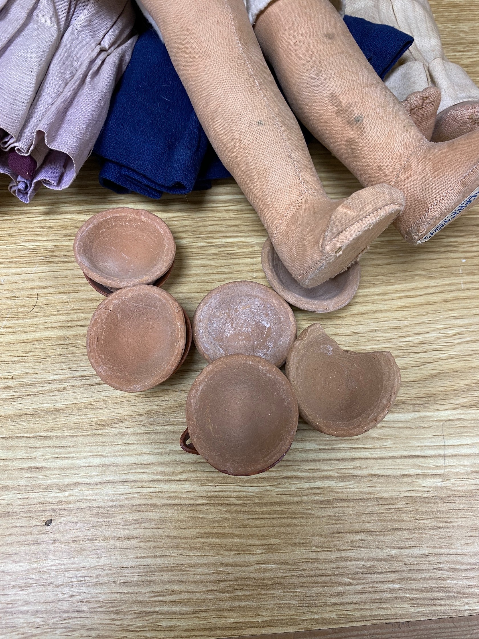 A Farnell’s Alpha Toys felt doll, 46cm, three Mexican souvenir cloth dolls and various clay toy dishes